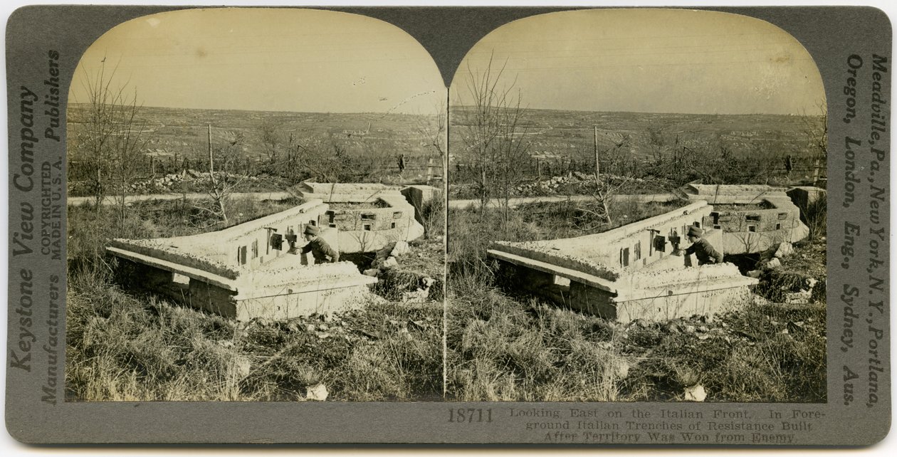 Pozioma stereokarta w sepii przedstawiająca umundurowanego mężczyznę stojącego za betonowymi okopami na otwartym polu. Keystone Stereograph numer 18711. Tytuł brzmi autorstwa Keystone View Company