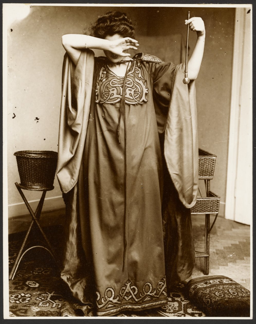 [Modelka stojąca z jedną ręką nad twarzą, trzymająca kulę w drugiej]. autorstwa Alphonse Maria Mucha