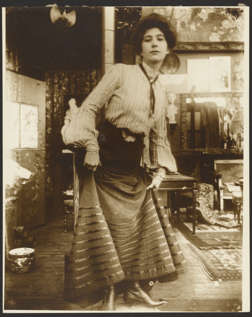 [Modelka w bluzce w paski i długiej sukience, Paryż] autorstwa Alphonse Maria Mucha