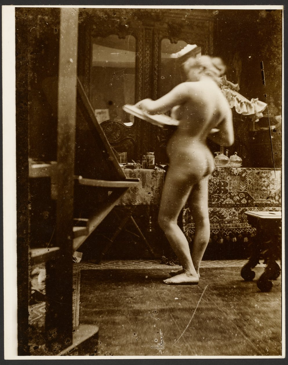 [Modelka stojąca w studiu i trzymająca szkicownik] autorstwa Alphonse Maria Mucha