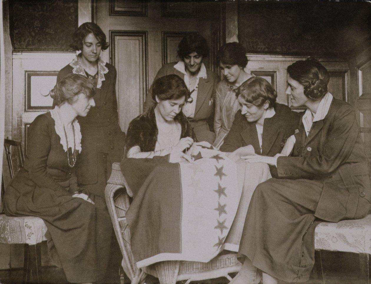 Alice Paul szyje gwiazdy na flagi sufrażystek, na co patrzą inne kobiety, ok. 1920 r autorstwa American Photographer
