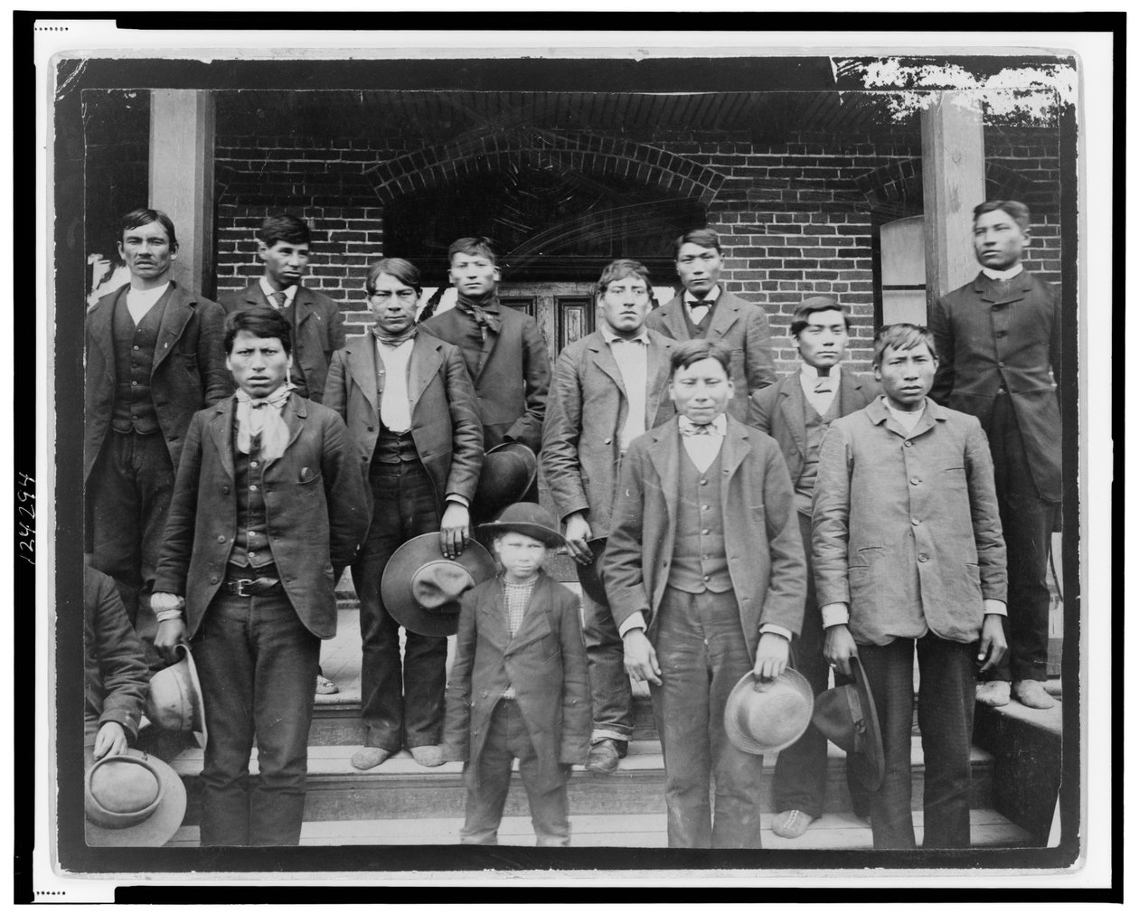 Rdzenni Amerykanie i chłopiec pozowani przed Carlisle Indian School, Pensylwania, ok. 1890 (zdjęcie czarno-białe) autorstwa American Photographer