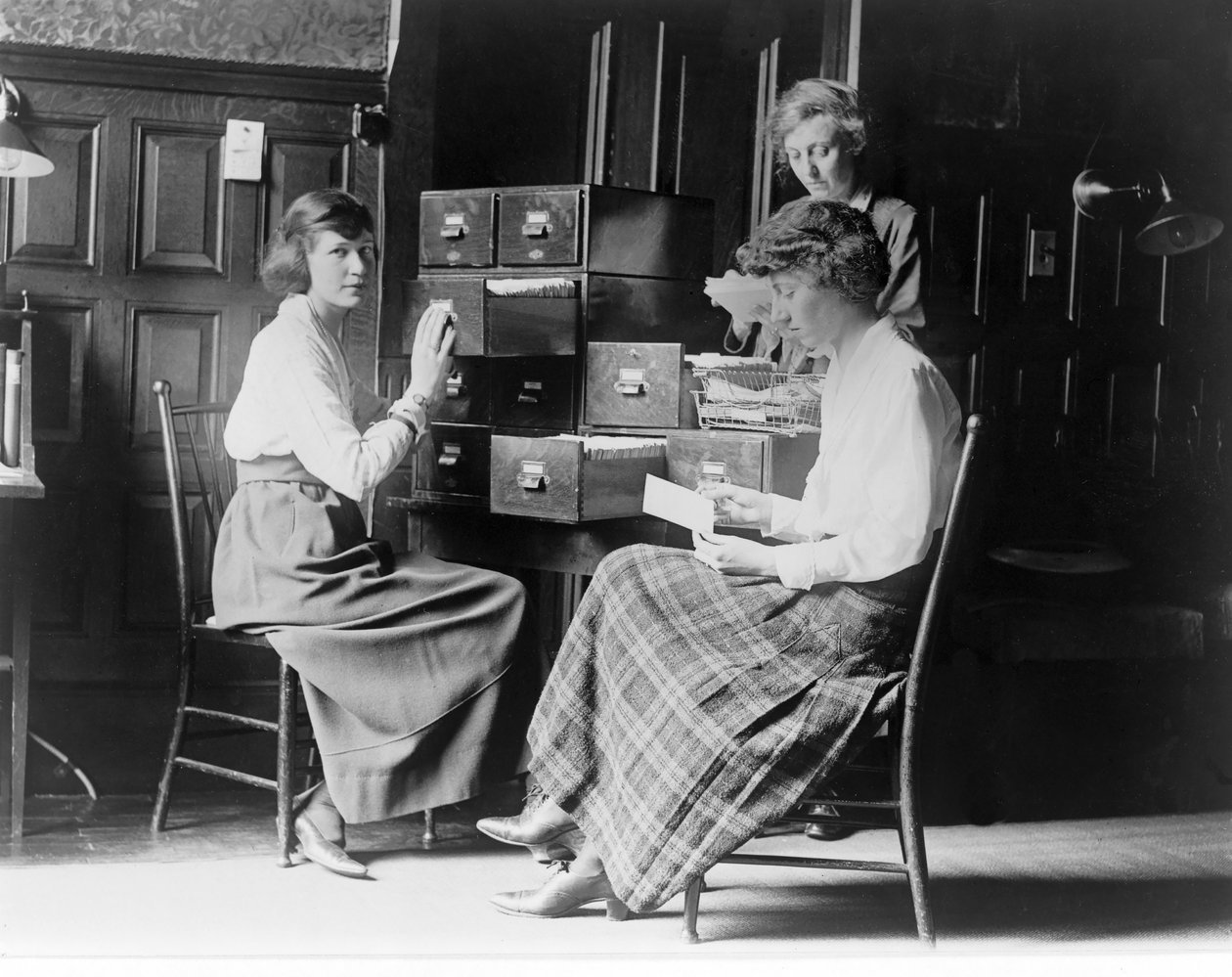 Trzy kobiety pracują w spisie kart w siedzibie Narodowej Partii Kobiet w Waszyngtonie, pub. ok. 1920 autorstwa American Photographer