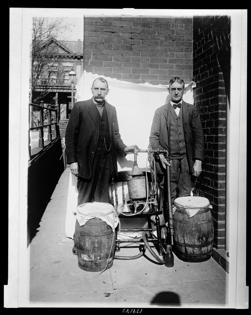 Dwóch mężczyzn pozujących z destylatorem whisky autorstwa American Photographer