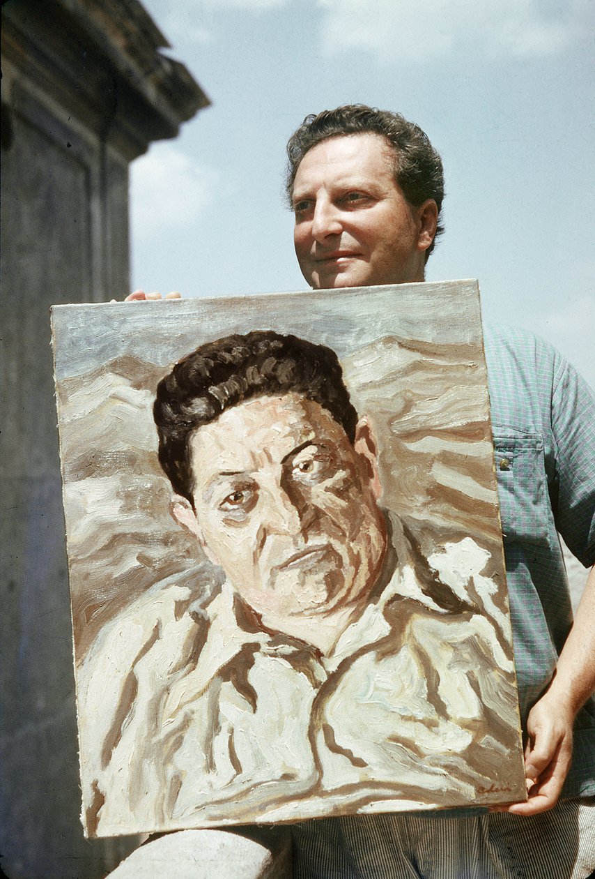 Włoski malarz i pisarz Carlo Levi (1902-1975) trzymający jedno ze swoich dzieł, portret związkowca Giuseppe di Vittorio (zdjęcie) autorstwa Ando Gilardi