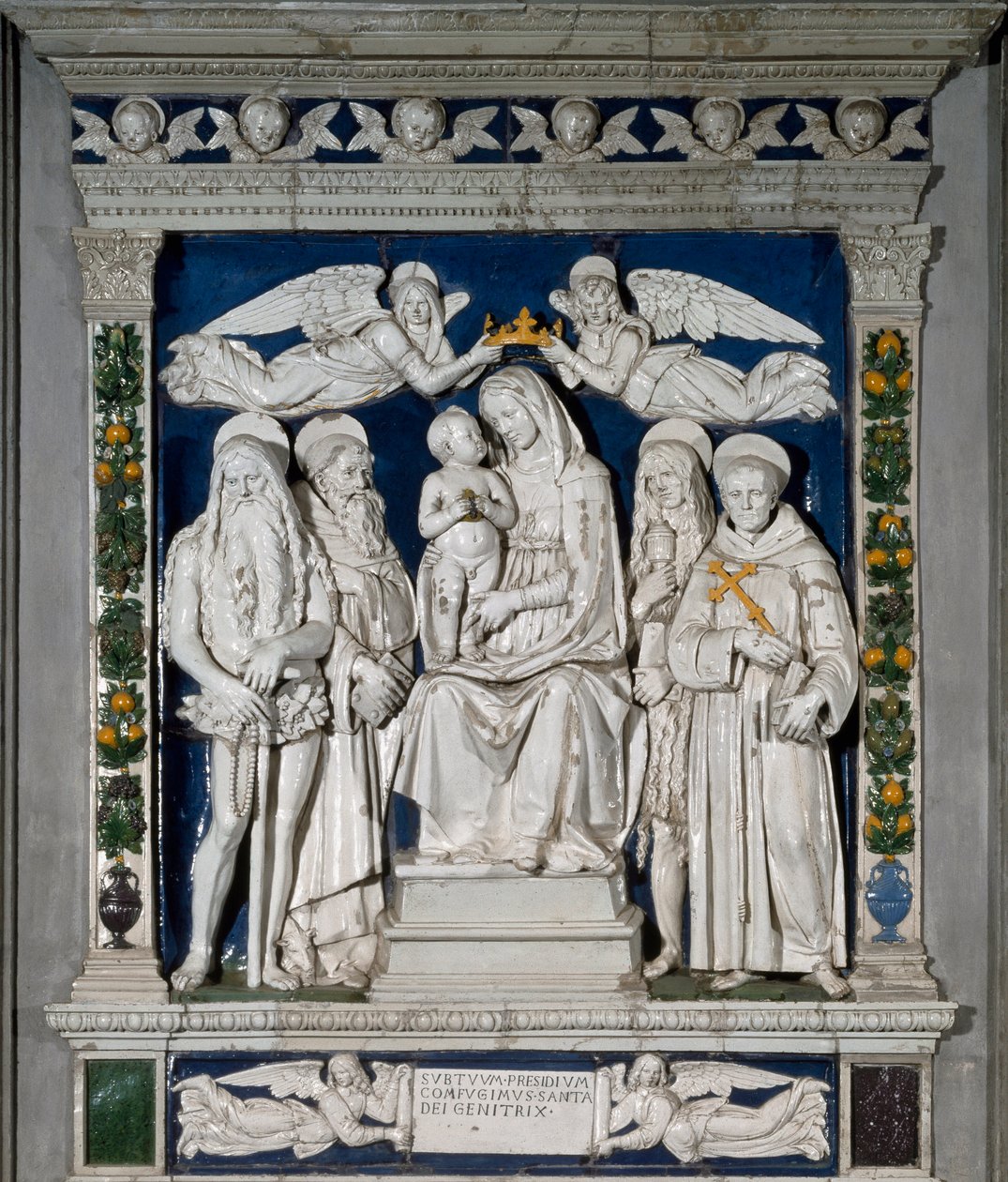 Dziewica Schronienia Dziewica Maryja i Dzieciątko Jezus w otoczeniu św. Onufrego Anachorety (lub Wielkiego), św. Antoniego Wielkiego” (św. Antoniego Opata (250/251-356) (lub św. Maria Magdalena i św. Franciszek z autorstwa Andrea Della Robbia