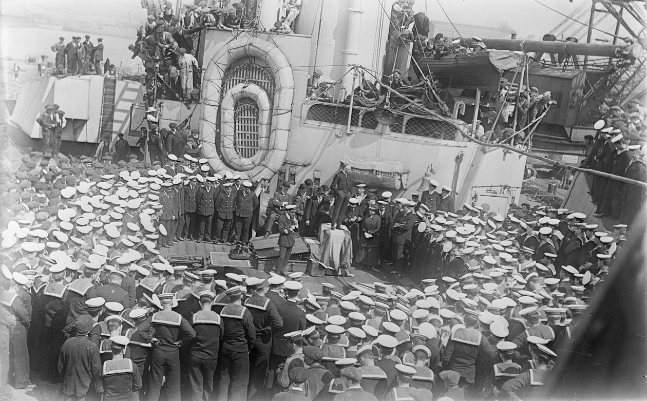 Marynarze tłoczą się wokół australijskiego premiera Hon Williama Morrisa (Billy) Hughesa, który przemawia do nich na pokładzie HMAS Australia w stoczni w Devon w Anglii, 21 maja 1916 r. autorstwa Australian Photographer