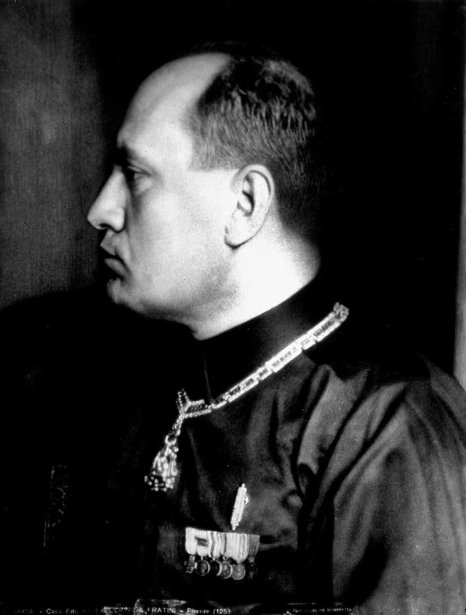 Portret w połowie długości w profilu Benito Mussoliniego w czarnej koszuli i odznaczeniach wojskowych (zdjęcie czarno-białe) autorstwa Brogi Brogi