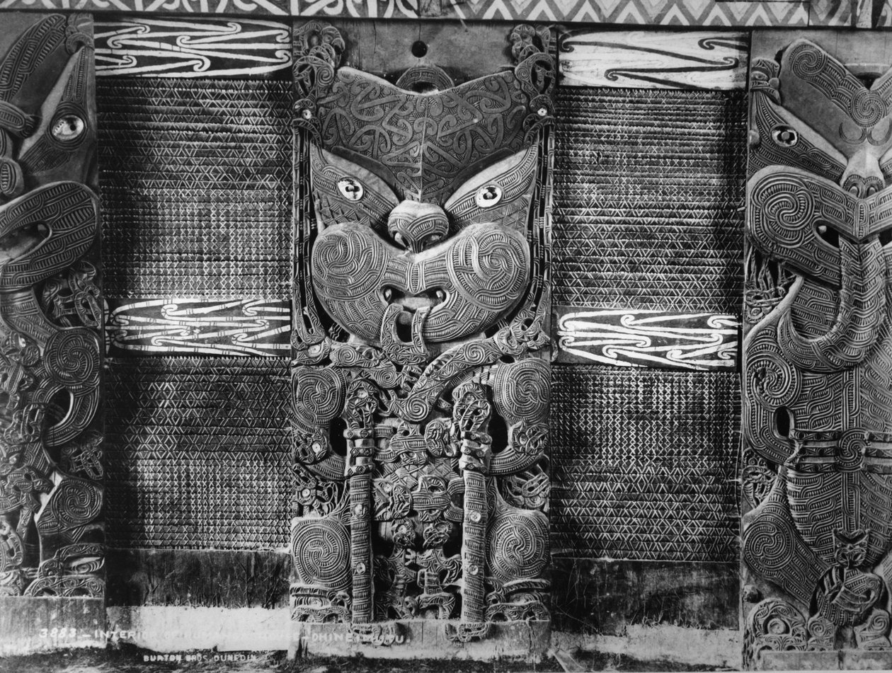 Rzeźby maoryskie i panele tukutuku w domu spotkań Tamatekapua w Ohinemutu, ok. 1880 r. autorstwa Burton Brothers Studio