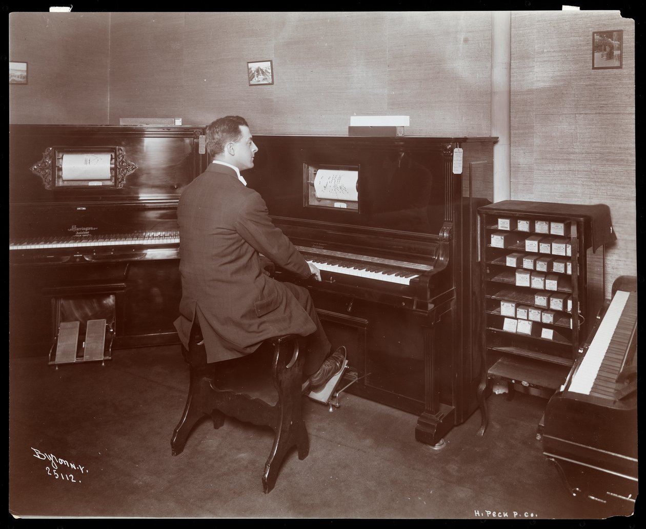 Mężczyzna grający na pianinie w salonie fortepianowym w Nowym Jorku, 1907 (srebrna odbitka żelatynowa) autorstwa Byron Company