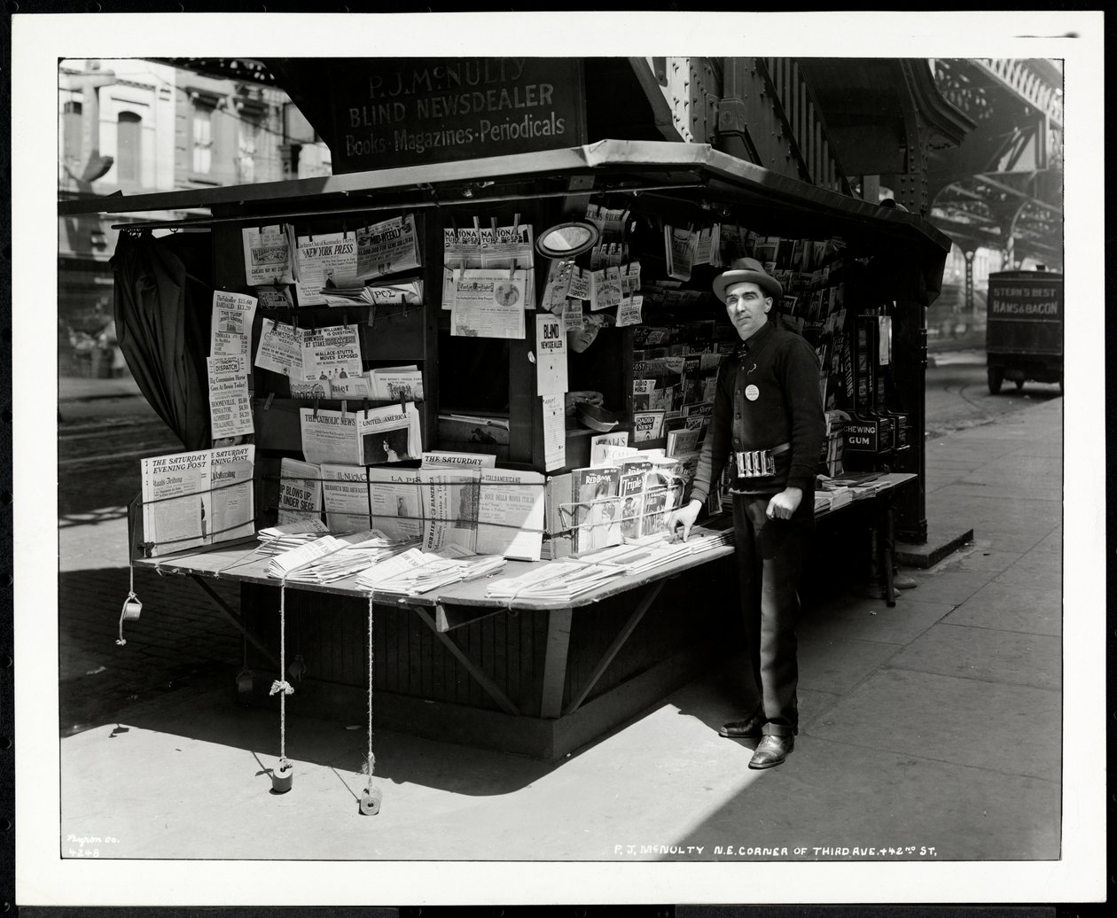 Niewidomy sprzedawca wiadomości P.J. McNulty na swoim stoisku na północno-wschodnim rogu 3rd Avenue i 42nd Street, Nowy Jork, 1926 (srebrny odbitka żelatynowa) autorstwa Byron Company