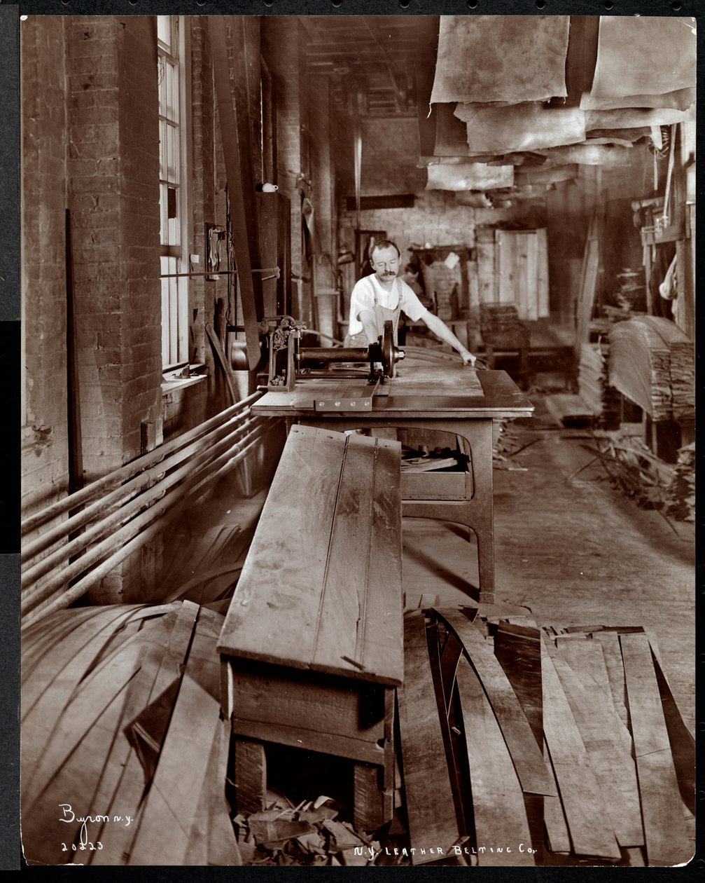 Widok wnętrza mężczyzny pracującego ze skórą w New York Leather Belting Co., Nowy Jork, 1905 (srebrny odbitka żelatynowa) autorstwa Byron Company