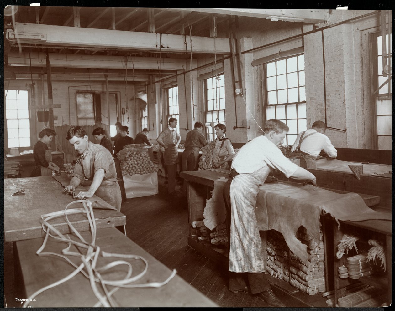 Widok wnętrza mężczyzn i kobiet pracujących ze skórą w New York Leather Belting Co., Nowy Jork, 1906 (srebrny odcisk żelatynowy) autorstwa Byron Company