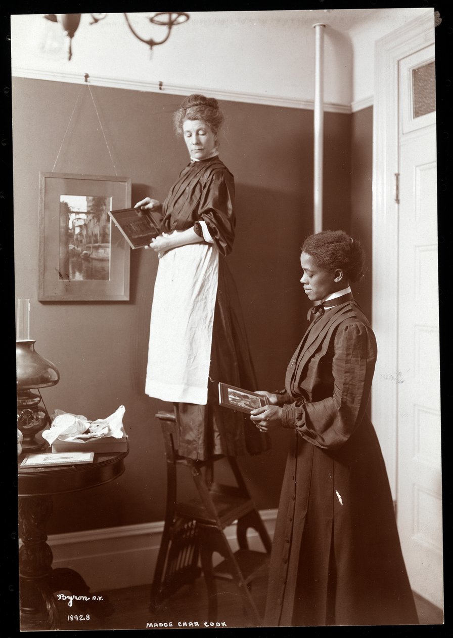 Madge Carr Cook wiesza obrazy ze swoją służącą, ok. 1904 (srebrny odbitka żelatynowa) autorstwa Byron Company