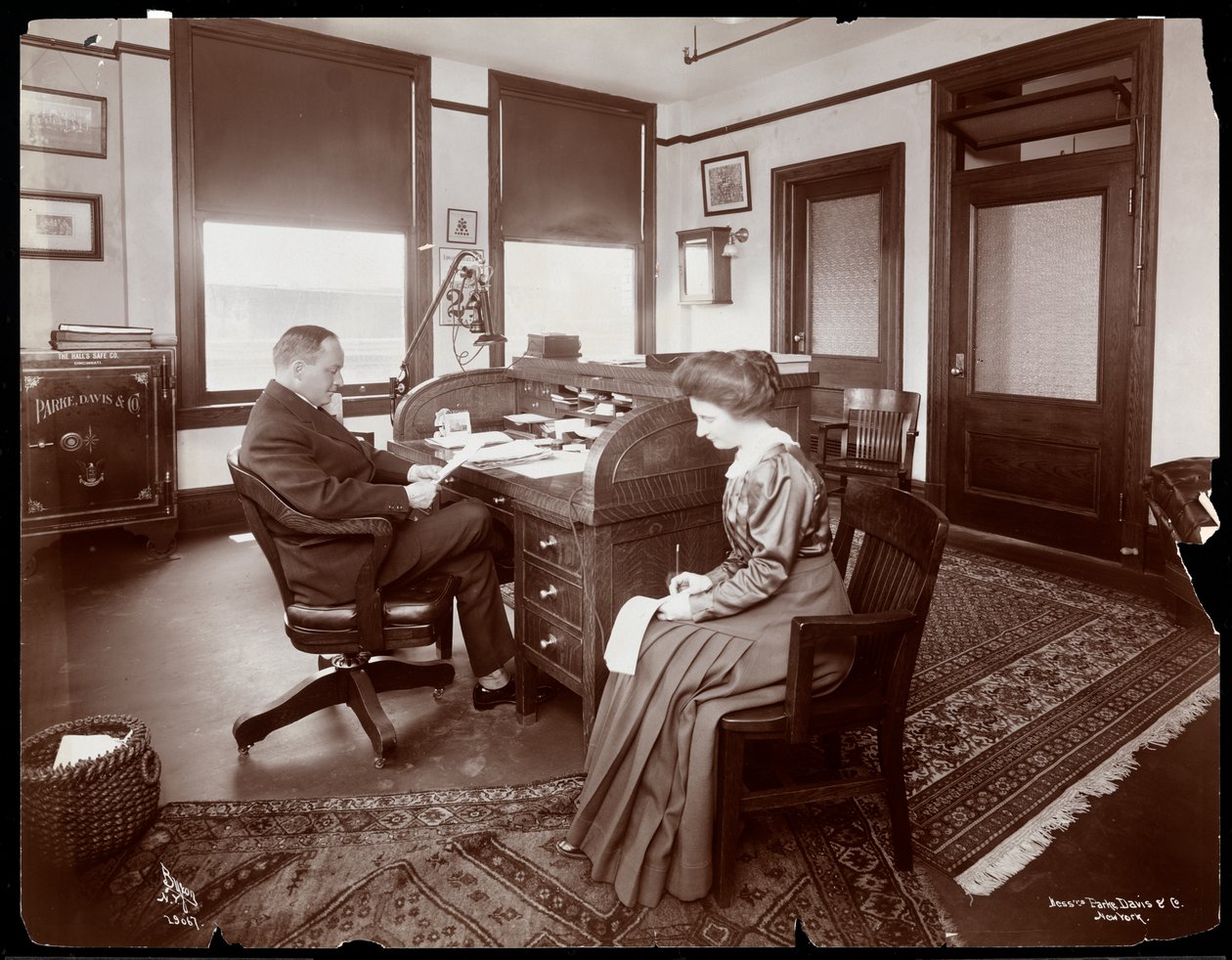 Mężczyzna ze swoją sekretarką dyktuje w prywatnym gabinecie w Parke, Davis und Co., apteka, Hudson und Vestry Streets, Nowy Jork, 1910 (srebrny odbitka żelatynowa) autorstwa Byron Company
