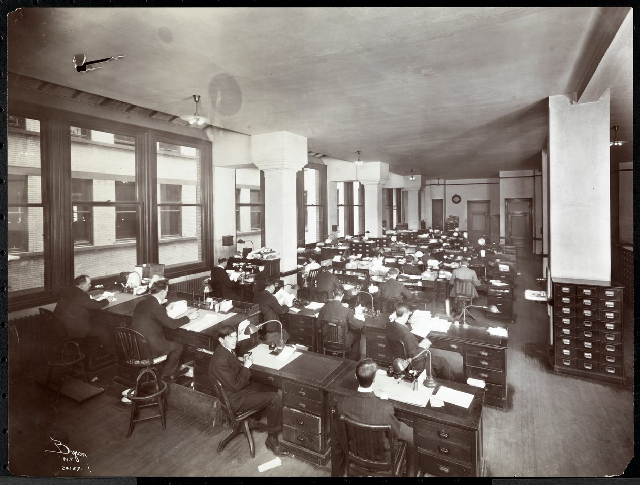 Mężczyźni i jedna kobieta pracują przy biurkach w biurze Metropolitan Life Insurance Co. przy 23rd Street i Madison Avenue, Nowy Jork, 1907 (srebrny odbitka żelatynowa) autorstwa Byron Company