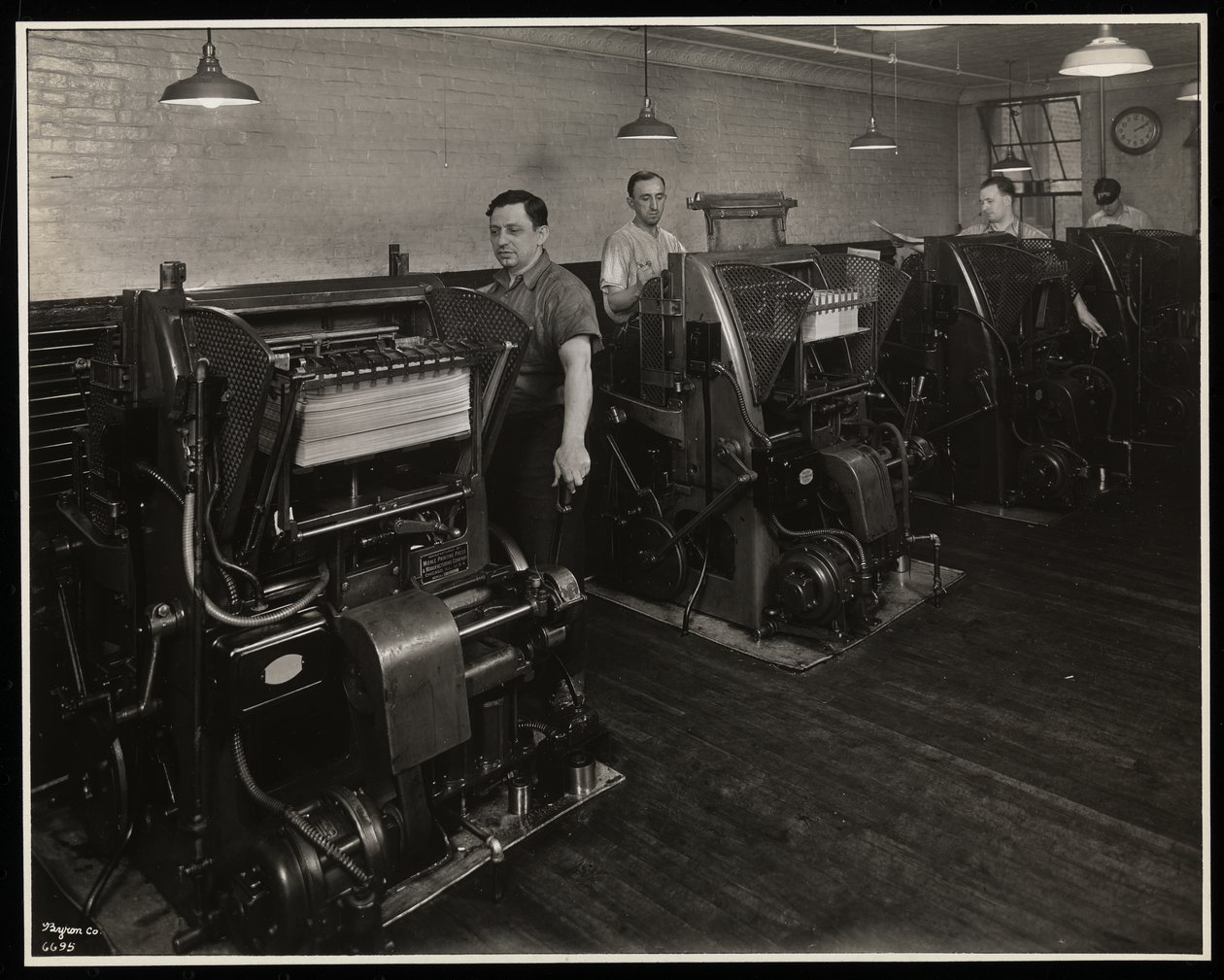 Mężczyźni pracujący przy maszynach drukarskich w Unz und Co., 24 Beaver Street, Nowy Jork, 1932 (odbitka żelatynowa) autorstwa Byron Company