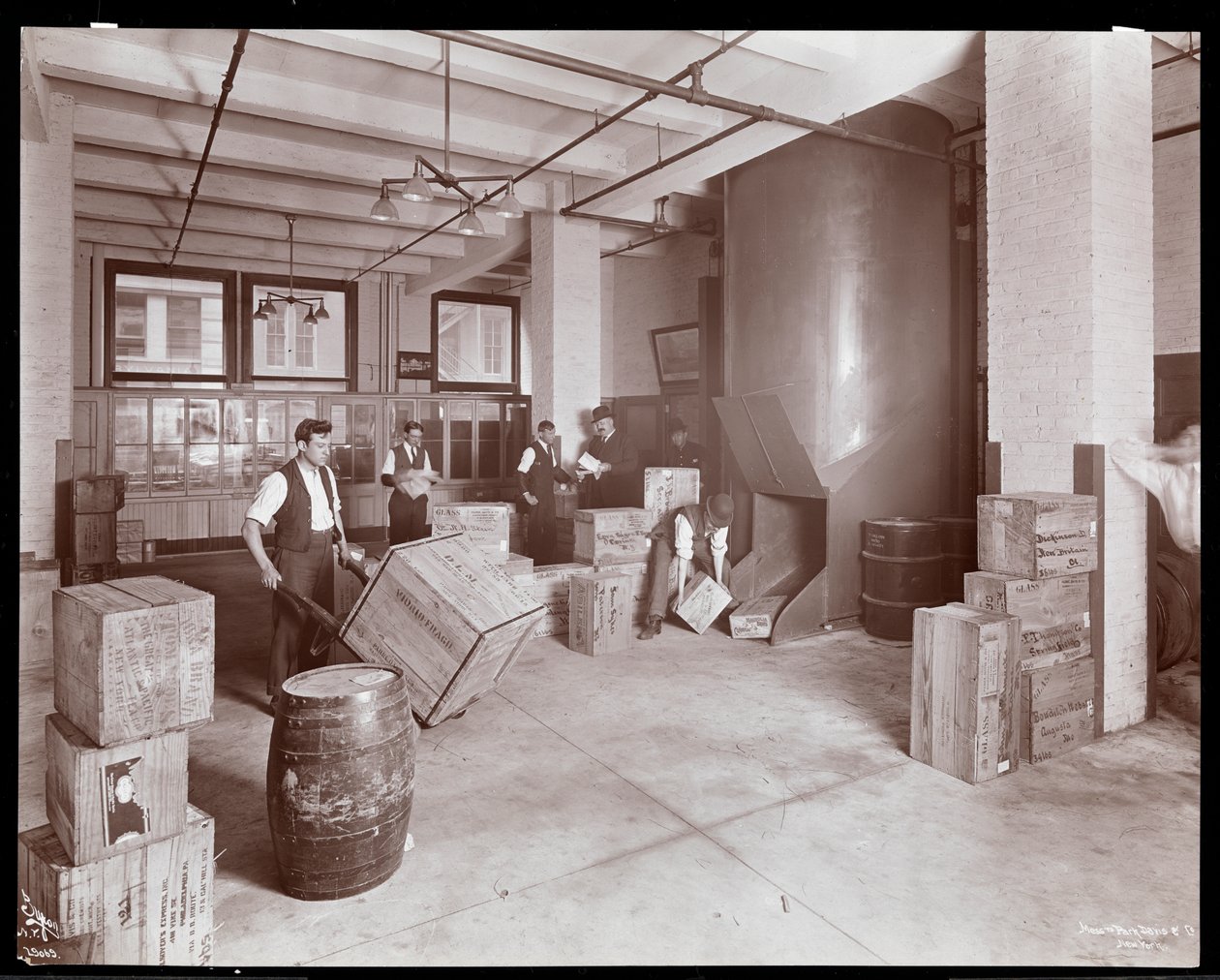 Mężczyźni pracujący ze skrzyniami w dziale wysyłkowym Parke, Davis und Co., chemicy, Hudson und Vestry Streets, Nowy Jork, 1910 (srebrny odcisk żelatynowy) autorstwa Byron Company
