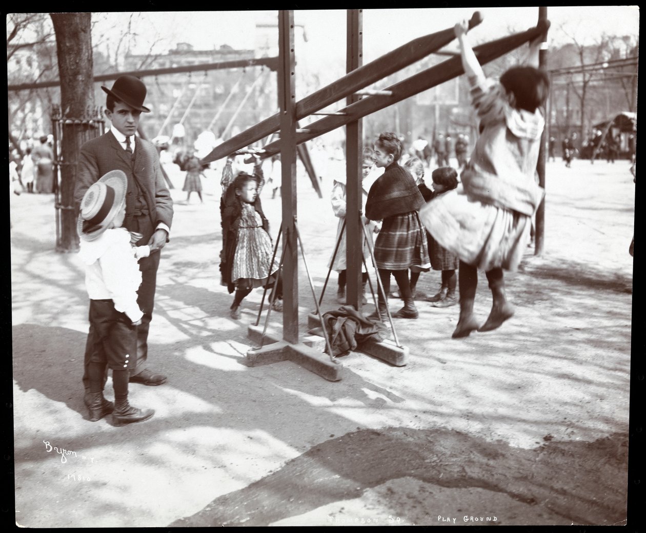 Widok mężczyzny nadzorującego dzieci bawiące się na placu zabaw w Tompkins Square Park, w dzień Arbor, Nowy Jork, 1904 (srebrny odbitka żelatynowa) autorstwa Byron Company