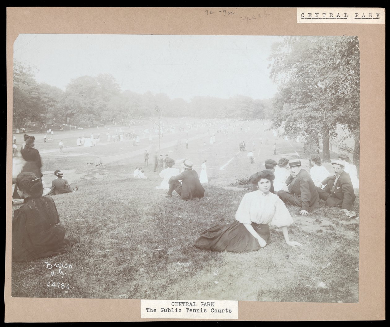 Widok mężczyzn i kobiet siedzących na trawie obserwujących tenis ziemny w Central Parku, Nowy Jork, ok. 1917 (srebrny odbitka żelatynowa) autorstwa Byron Company