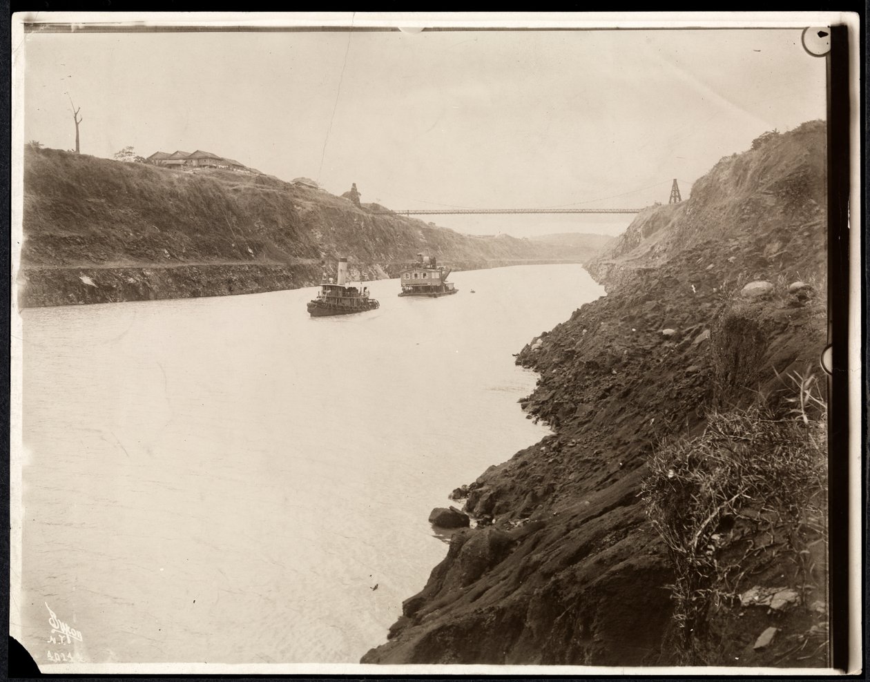 Widok dwóch łodzi na Kanale Panamskim podczas jego budowy z mostem wiszącym za nim, 1913 (srebrny odbitka żelatynowa) autorstwa Byron Company