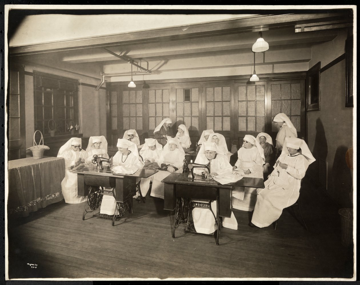 Kobiety noszące białe kitle, na lekcji szycia, przypuszczalnie w czasie lub w związku z I wojną światową, Nowy Jork, ok. 1920 (srebrny odcisk żelatynowy) autorstwa Byron Company