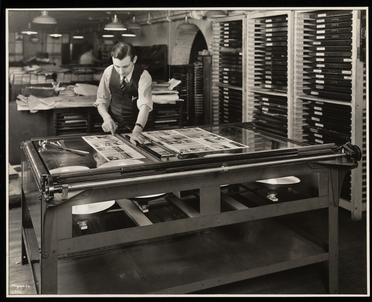 Praca nad układem graficznym przy stole oświetleniowym w Unz und Co., 24 Beaver Street, Nowy Jork, 1932 (odbitka żelatynowa) autorstwa Byron Company