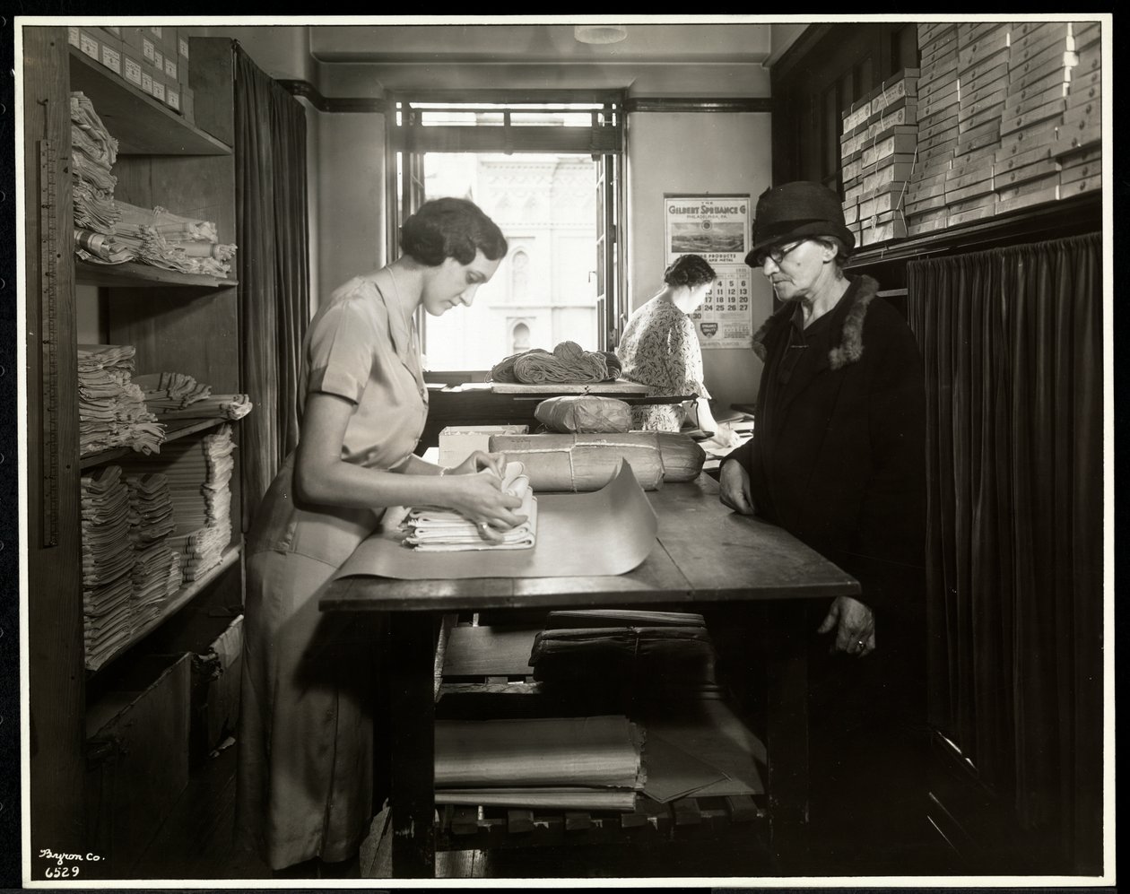 Młoda kobieta owijająca materiały dla chałupniczki do zabrania ze sobą, w nowojorskim stowarzyszeniu dla niewidomych, 111 East 59th Street, Nowy Jork, 1931 (srebrny odbitka żelatynowa) autorstwa Byron Company