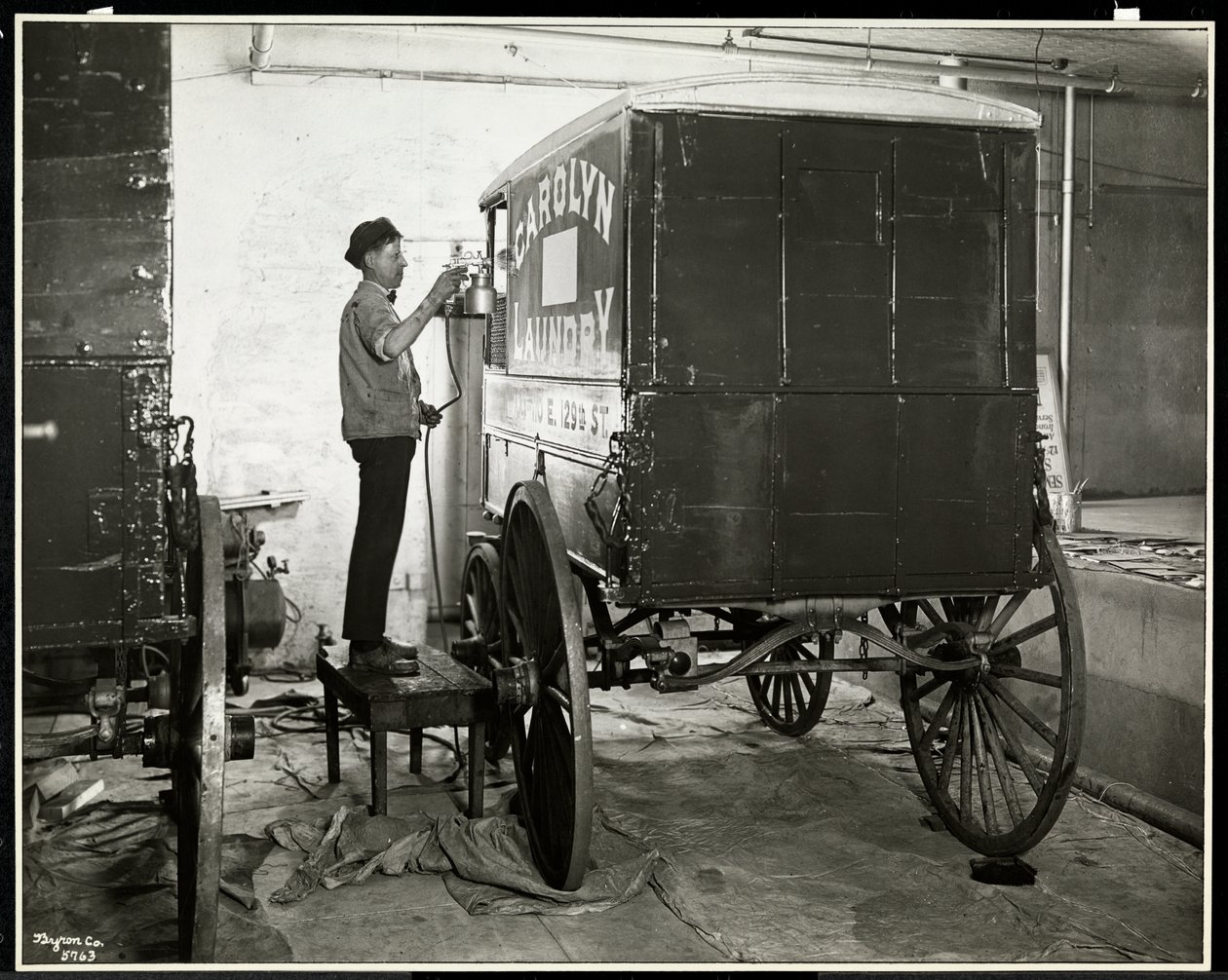 Mężczyzna malujący natryskowo wagon dostawczy Carolyn Laundry przy 111 East 128th Street, East Harlem, Nowy Jork, 1929 (srebrny odbitka żelatynowa) autorstwa Byron Company