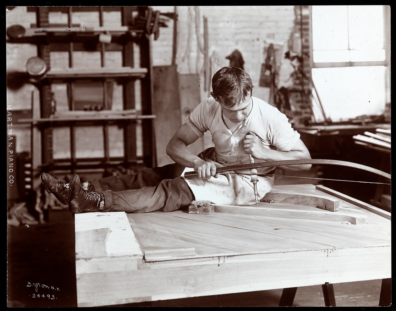Mężczyzna pracujący w fabryce fortepianów Hartman Piano Co., 1907 (odbitka żelatynowa) autorstwa Byron Company