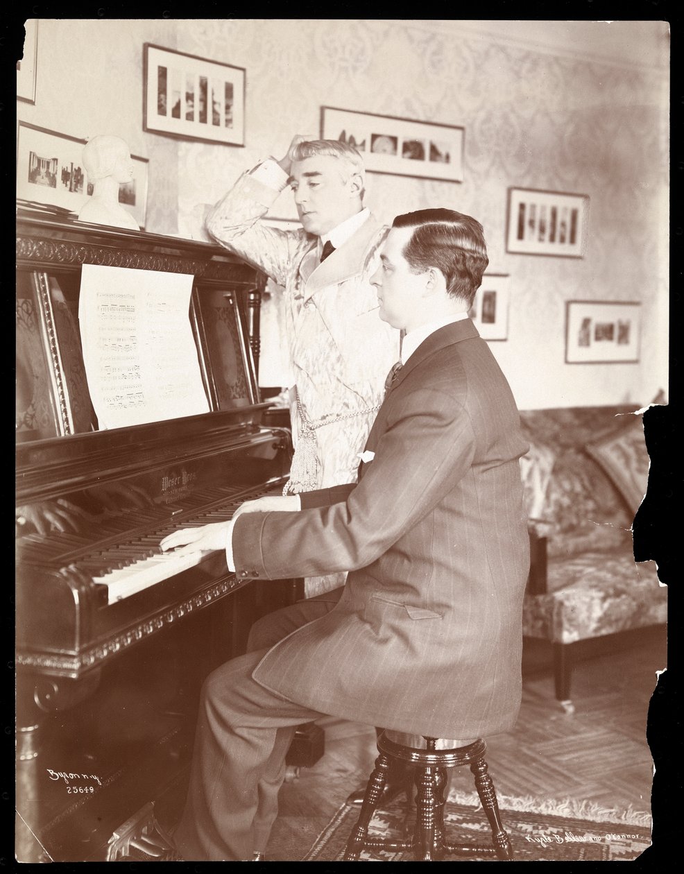 Kyrle Bellew i przyjaciel przy fortepianie w domu Bellewa, 1908 (odbitka żelatynowa srebrna) autorstwa Byron Company