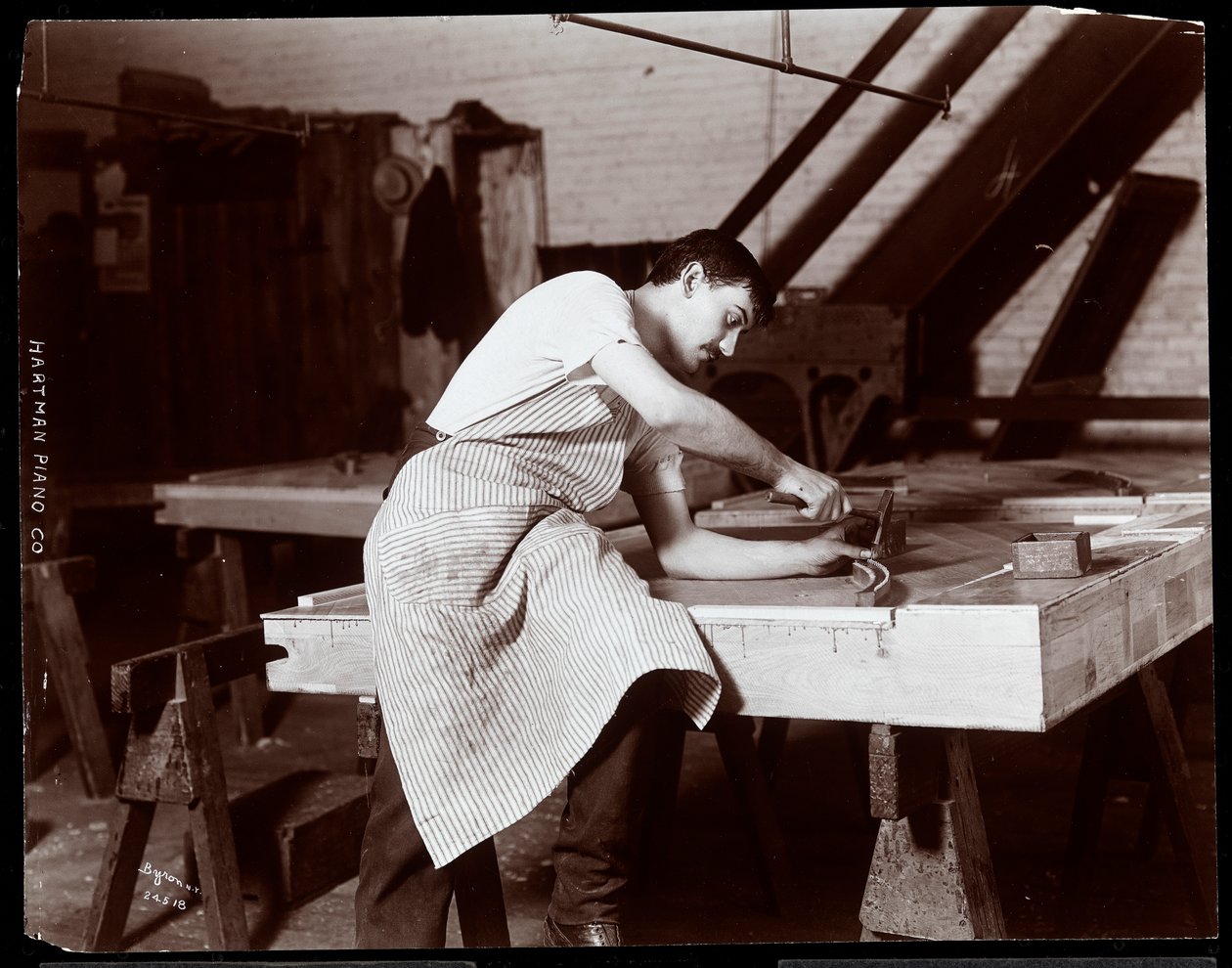 Mężczyzna pracujący w fabryce fortepianów Hardman, Peck und Co., Nowy Jork, 1907 (odbitka żelatynowa) autorstwa Byron Company