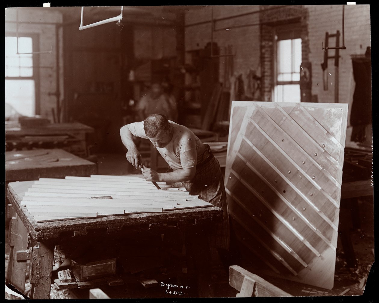 Mężczyzna pracujący w fabryce fortepianów Hardman, Peck und Co., Nowy Jork, 1907 (srebrny odbitka żelatynowa) autorstwa Byron Company