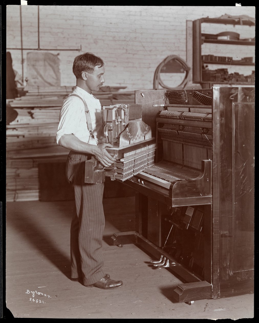 Mężczyzna pracujący w fabryce fortepianów Hardman, Peck und Co., Nowy Jork, 1907 (odbitka żelatynowa) autorstwa Byron Company