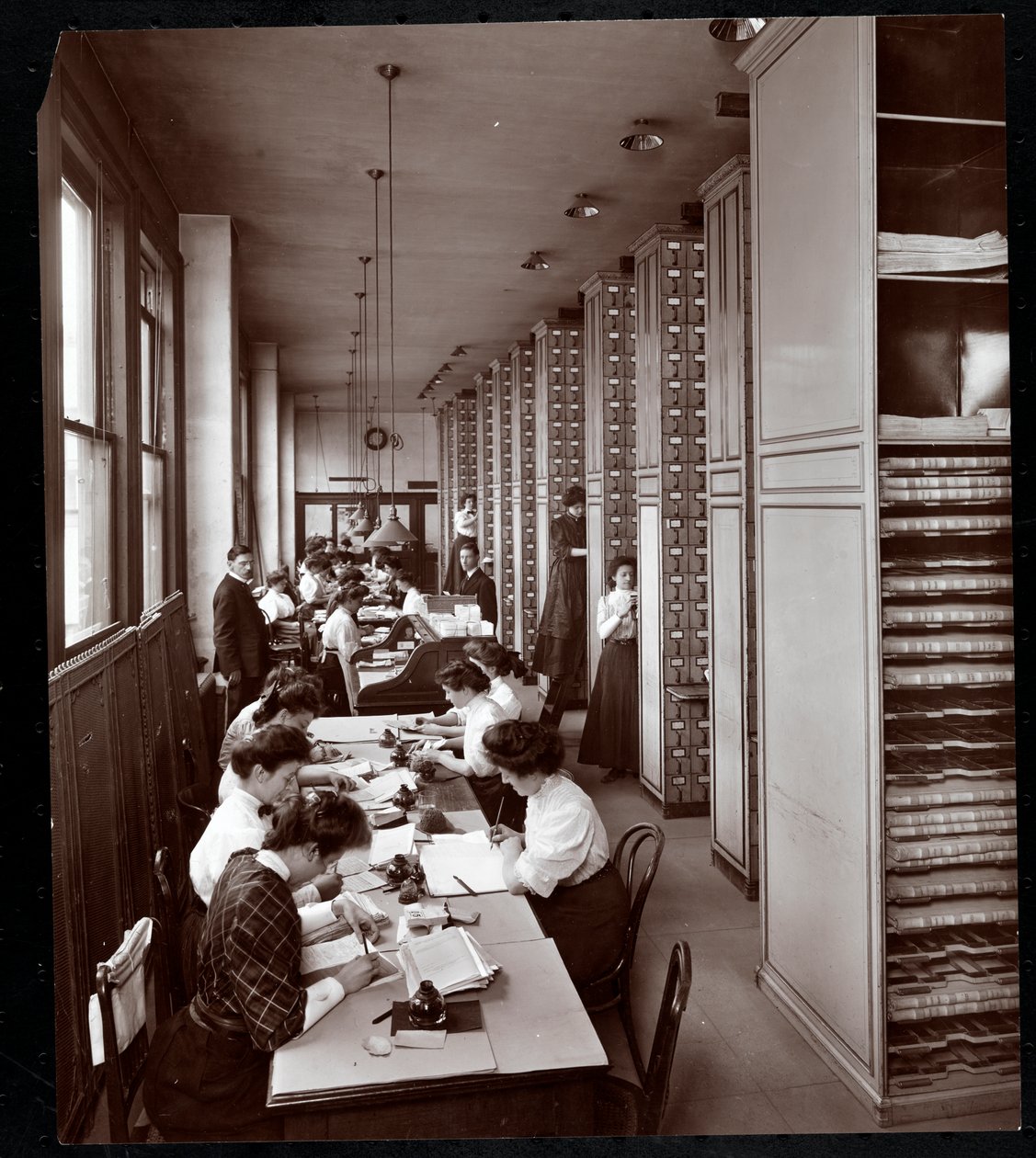 Kobiety pracujące w aktówce, pod męskim nadzorem, w Metropolitan Life Insurance Co. przy 23rd Street i Madison Avenue, Nowy Jork, 1907 (srebrny odbitka żelatynowa) autorstwa Byron Company