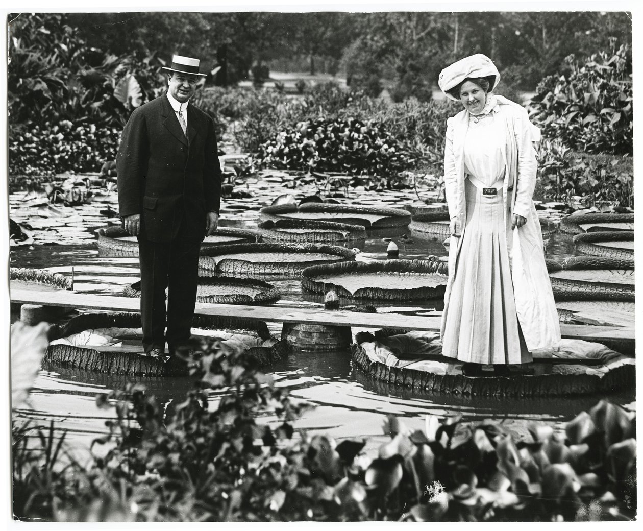 Tower Grove Park Lily Pond. Mężczyzna i kobieta stojąc na Lily Pads. autorstwa Charles Clement Holt