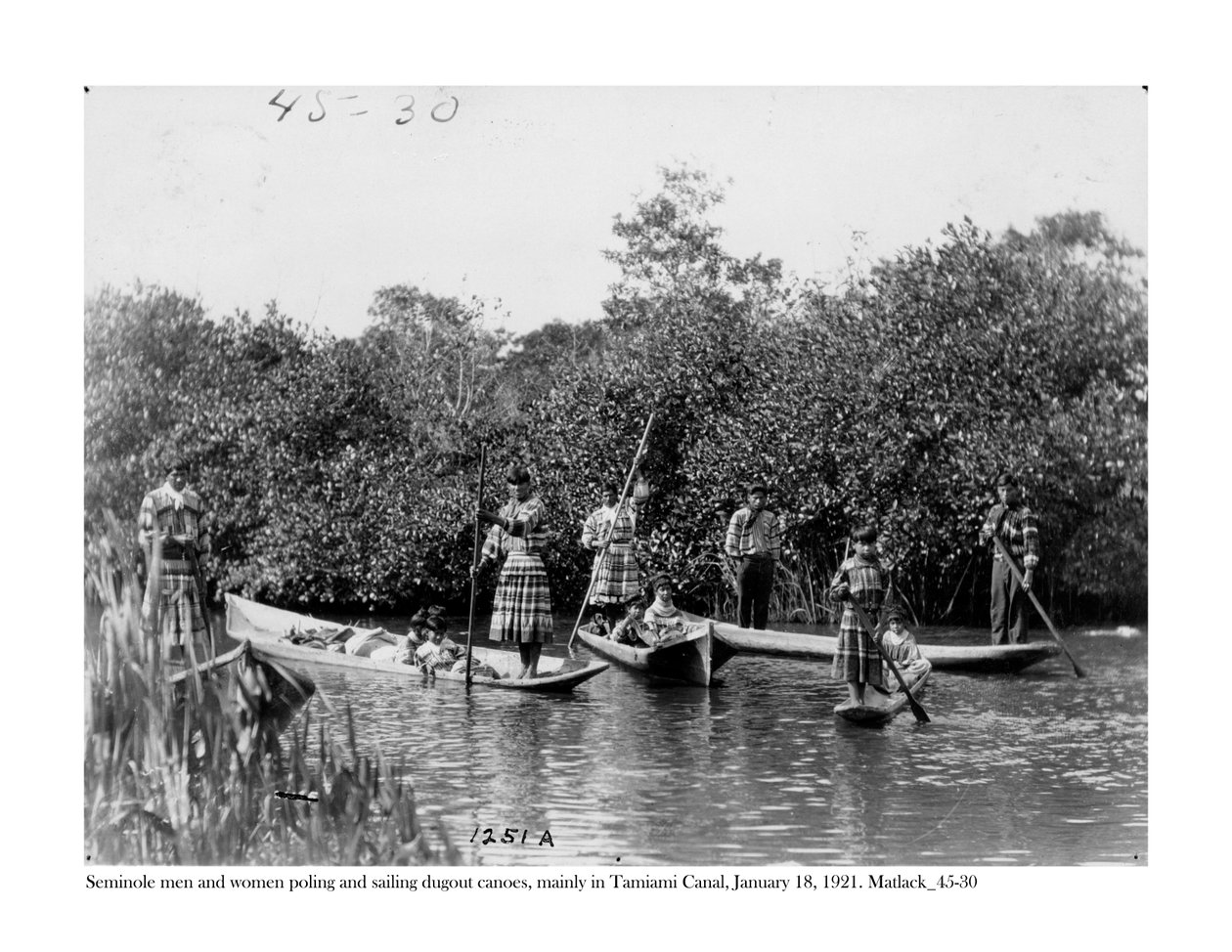 Seminole, mężczyźni i kobiety, żeglują i żeglują na czółnach na kanale Tamiami, 18 stycznia 1921 autorstwa Claude C. Matlack