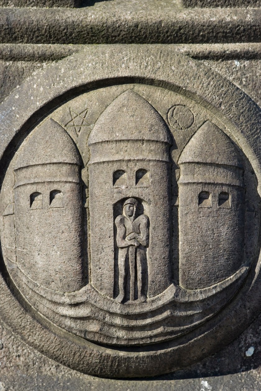 Symbol trzech wież wyrzeźbiony w kamiennej kolumnie na Placu Ratuszowym autorstwa Danish School