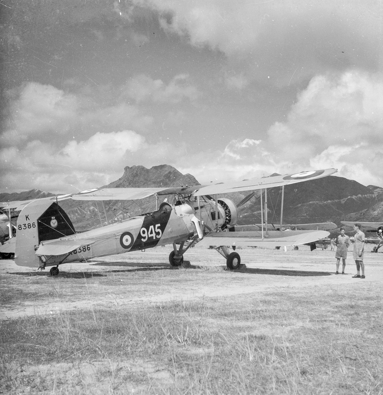 Dwupłatowy bombowiec torpedowy Fairey Swordfish I K8386, kod 945, z 824 Dywizjonu Lotnictwa Floty, na lotnisku Kai Tak, Hongkong autorstwa David Watkin Waters