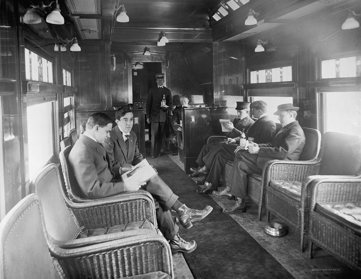 Grupa mężczyzn podróżujących w wagonie biblioteki bufetowej pociągiem Deluxe Overland Limited, USA, ok. 1915 r. (zdjęcie czarno-białe) autorstwa Detroit Publishing Co.