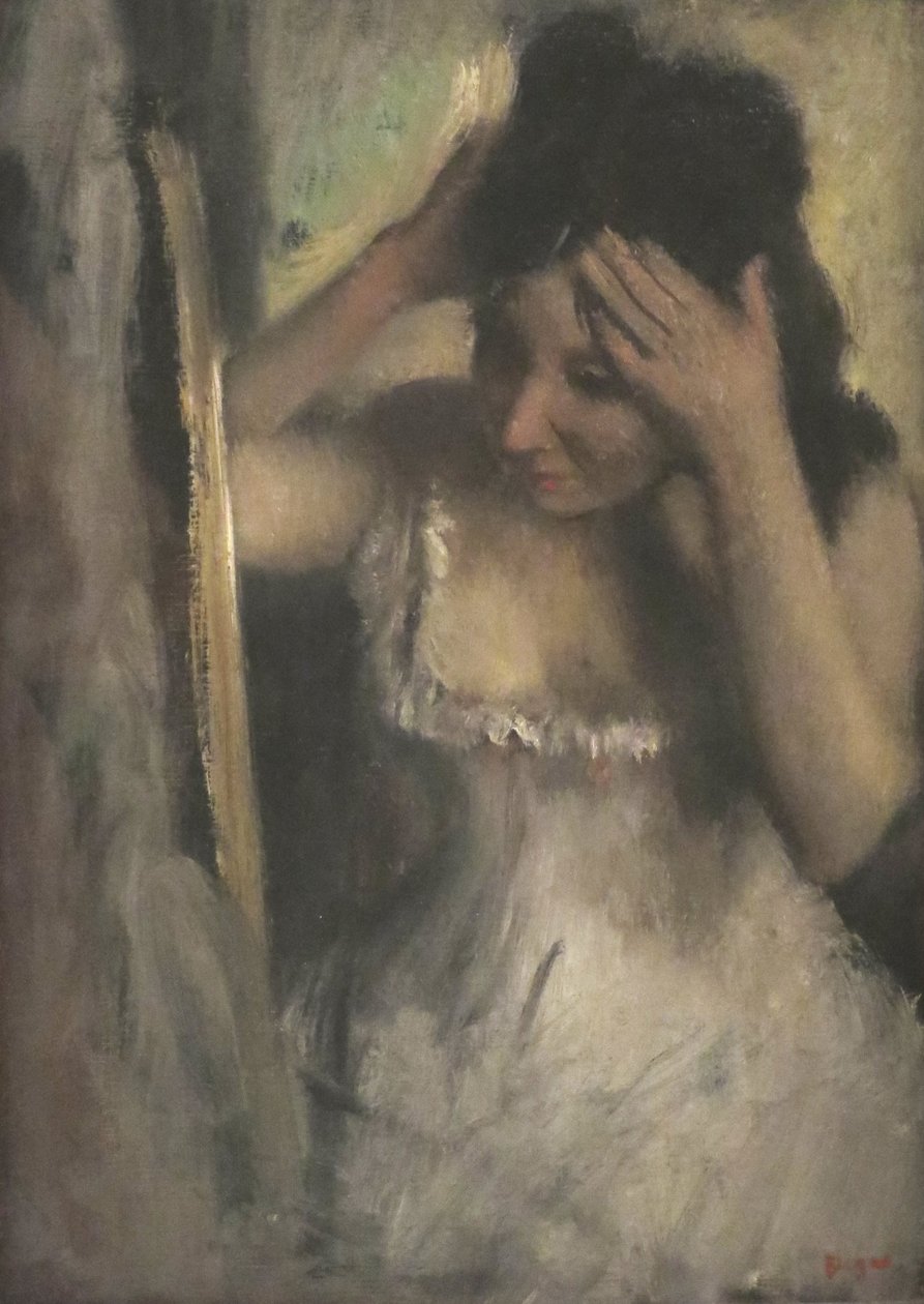Kobieta czesząca włosy przed lustrem autorstwa Edgar Degas