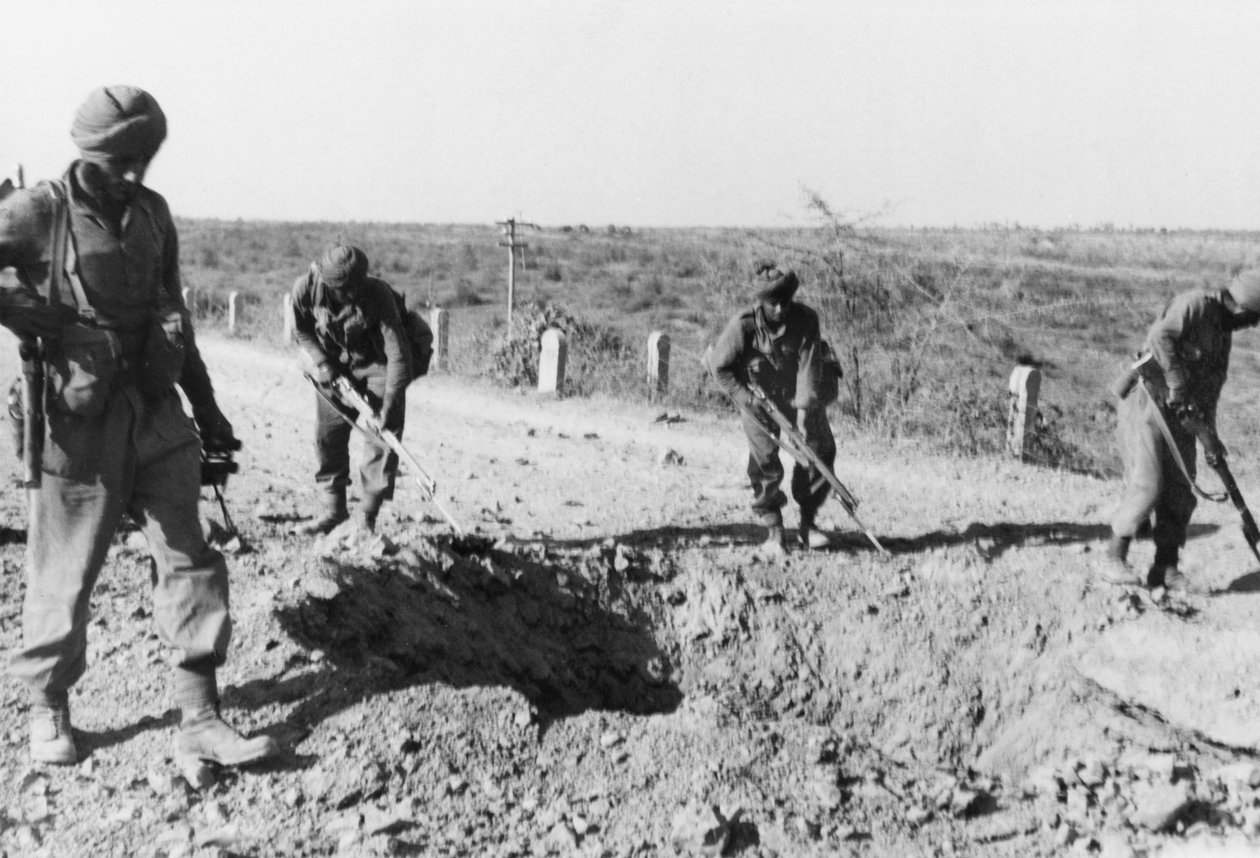 Żołnierze indyjscy szukający min wzdłuż polnej drogi, 1941 autorstwa English Photographer