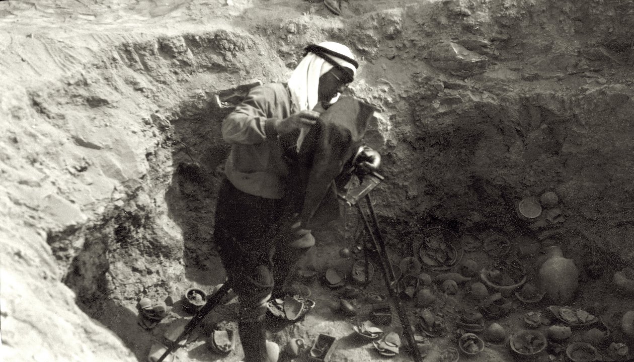 Profesor John Garstang fotografujący potłuczoną ceramikę in situ podczas wykopalisk w Jerychu, 1930-36 autorstwa English Photographer