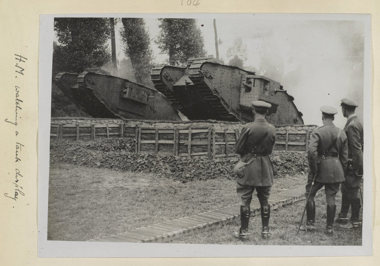 Trzech oficerów, prawdopodobnie król Jerzy V, obserwujących dwa czołgi przejeżdżające przez przeszkodę, 1915-18 autorstwa English Photographer