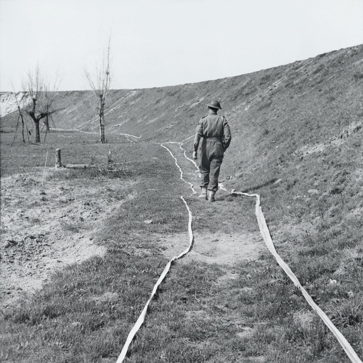 Biała taśma oznaczająca czyste ślady przez pole minowe, nad rzeką Senio, Włochy, marzec 1945 autorstwa English Photographer