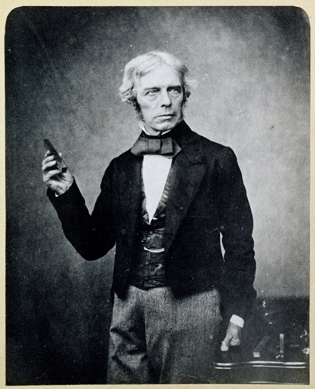Michael Faraday (1791-1867) trzymający magnes sztabkowy, Maull i Polyblank autorstwa English Photographer