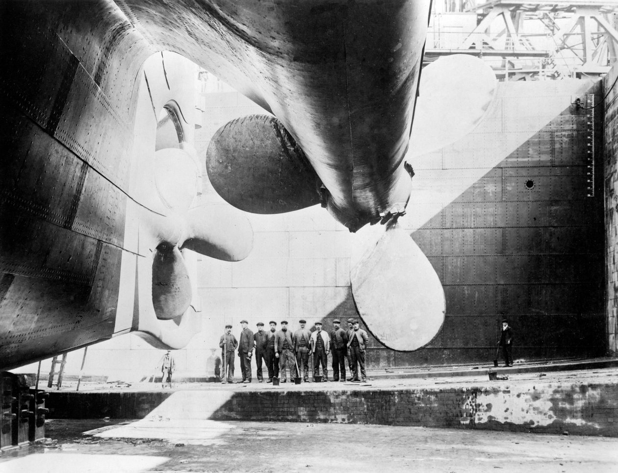 Robotnicy stojący pod jednym ze śmigieł Titanica, 31 maja 1911 r. autorstwa English Photographer
