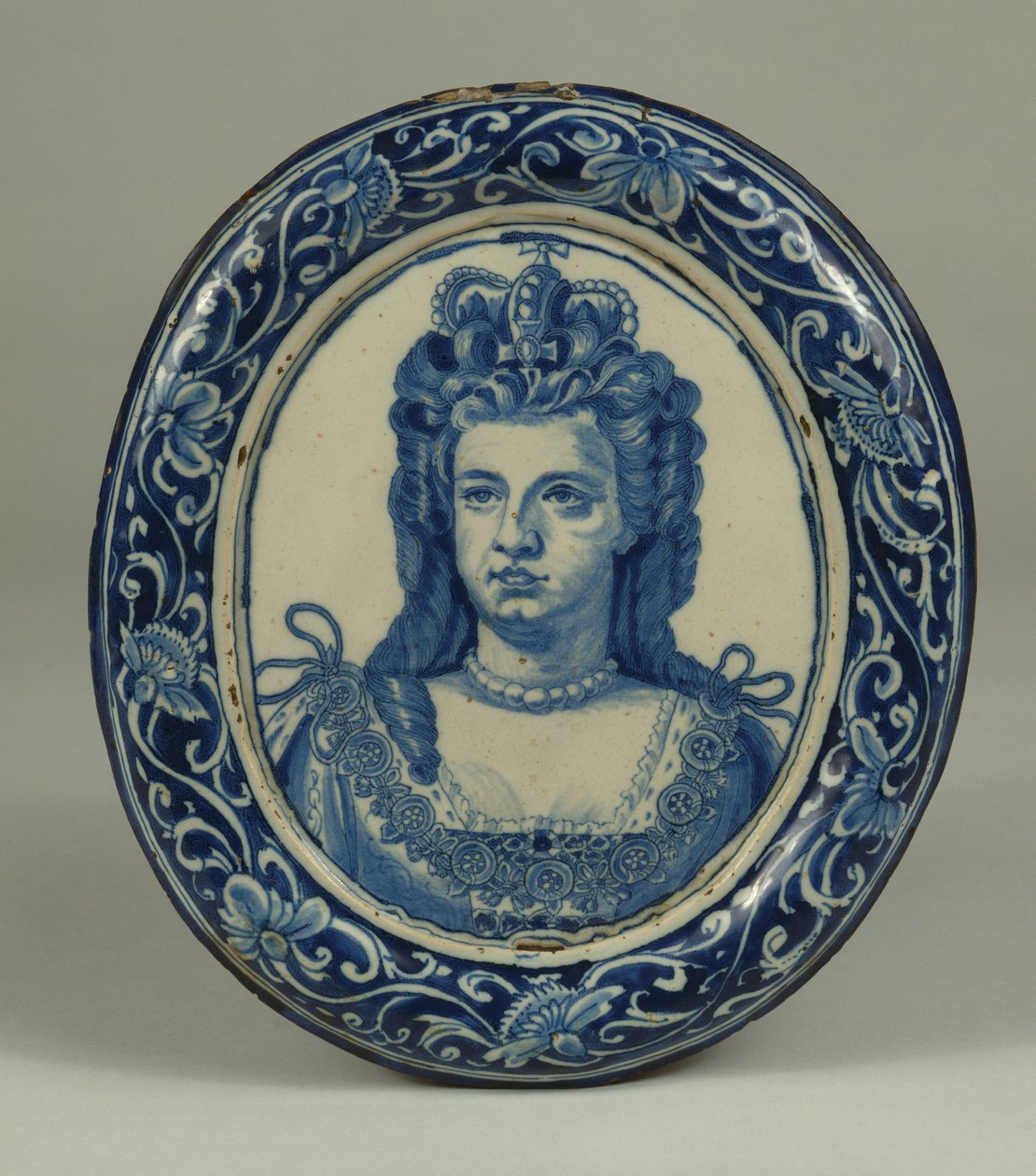 Niebiesko-biała owalna królewska plakietka przedstawiająca królową Annę Delft, prawdopodobnie Londyn, ok. 1705 r. autorstwa English School