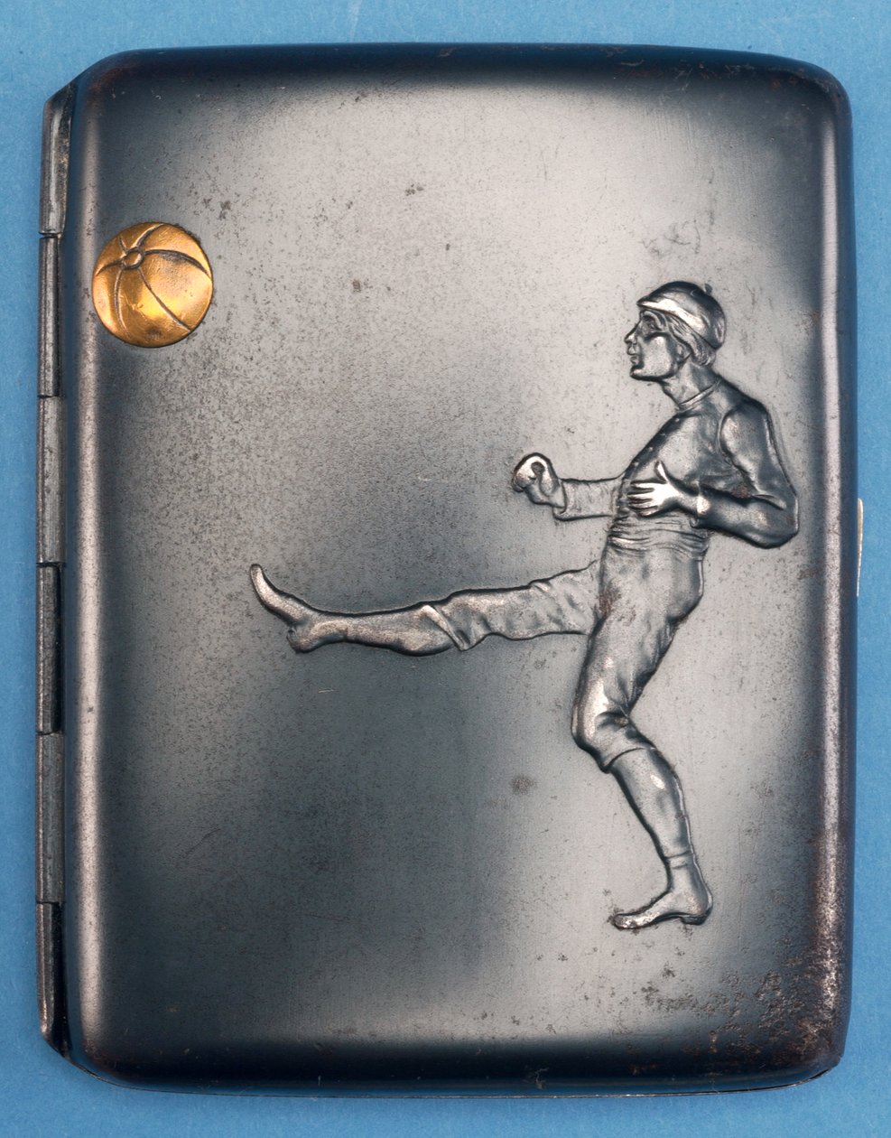 Papierośnica z piłkarzem kopiącym w powietrze złotą kulkę. ok.1880 (metal) autorstwa English School