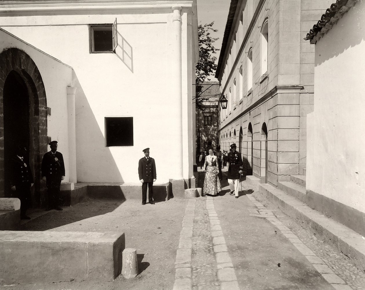 Mężczyźni w mundurze towarzyszący elegancko ubranej kobiecie w kierunku kościoła na farmie Lo Zucco, Sycylia, 1900 autorstwa Eugenio Interguglielmi